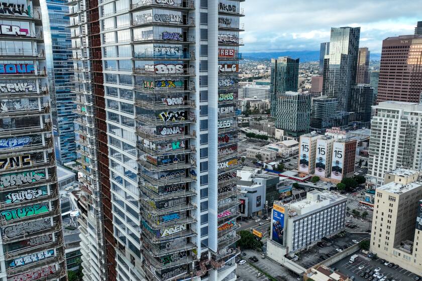 Los Angeles, CA, Thursday, February 1, 2024 - Taggers have graffitied what appears to be more than 25 stories of a downtown Los Angeles skyscraper that's been sitting dormant for several years. Construction on Oceanwide Plaza, a $1 billion mixed-use retail and luxury apartments project with three towering unfinished structures, stalled in January 2019 after the Beijing-based developer lacked the funds to complete it. (Robert Gauthier/Los Angeles Times)