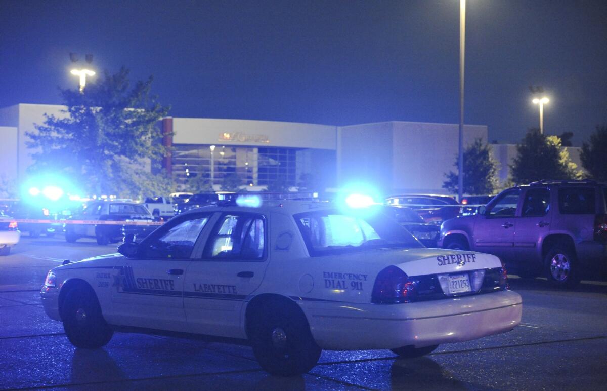 Police surround the Grand Theatre in Lafayette, La., after a shooting there Thursday night. Two moviegoers were killed and nine were injured.