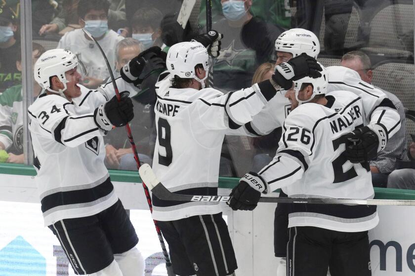 Los Angeles Kings Arthur Kaliyev (34), Adrian Kempe (9) and Sean Walker (26) celebrate a goal by center Gabriel Vilardi (13) against the Dallas Stars during the second period of an NHL hockey game Friday, Oct. 22, 2021, in Dallas. (AP Photo/Richard W. Rodriguez)