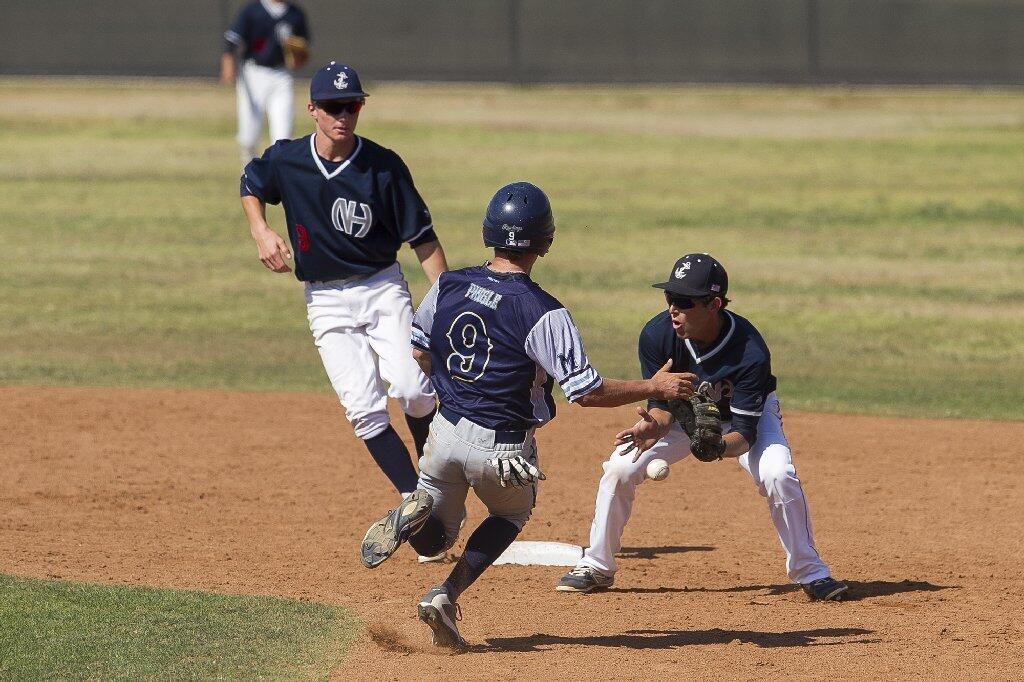 Newport Harbor High's Dylan Kaplan attempts to handle a throw on a stolen base from Marina's Will Pingle during a Sunset League game on Wednesday.