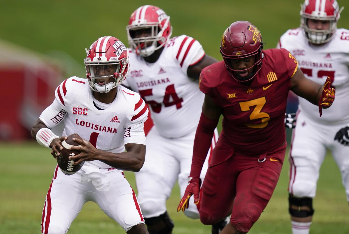 Louisiana-Lafayette quarterback Levi Lewi looks for an open receiver as Iowa State defensive end JaQuan Bailey chases him.