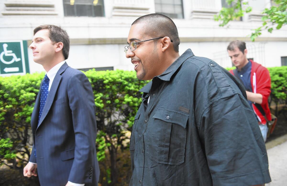 Hector Xavier Monsegur, right, walks out of federal court in New York after he was sentenced to time served.