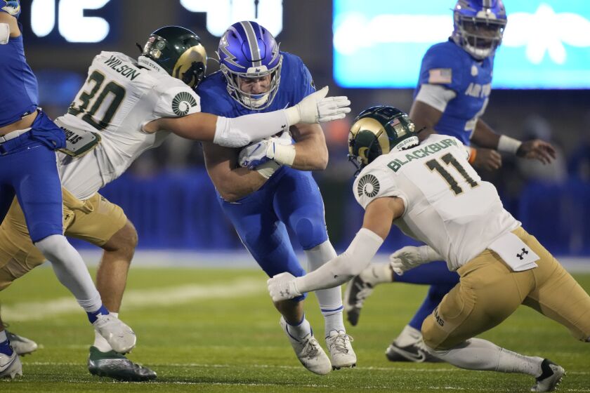 Air Force running back Brad Roberts, center, is stopped after a short gain by Colorado State linebacker Chase Wilson, left, and defensive back Henry Blackburn in the first half of an NCAA college football game Saturday, Nov. 19, 2022, at Air Force Academy, Colo. (AP Photo/David Zalubowski)