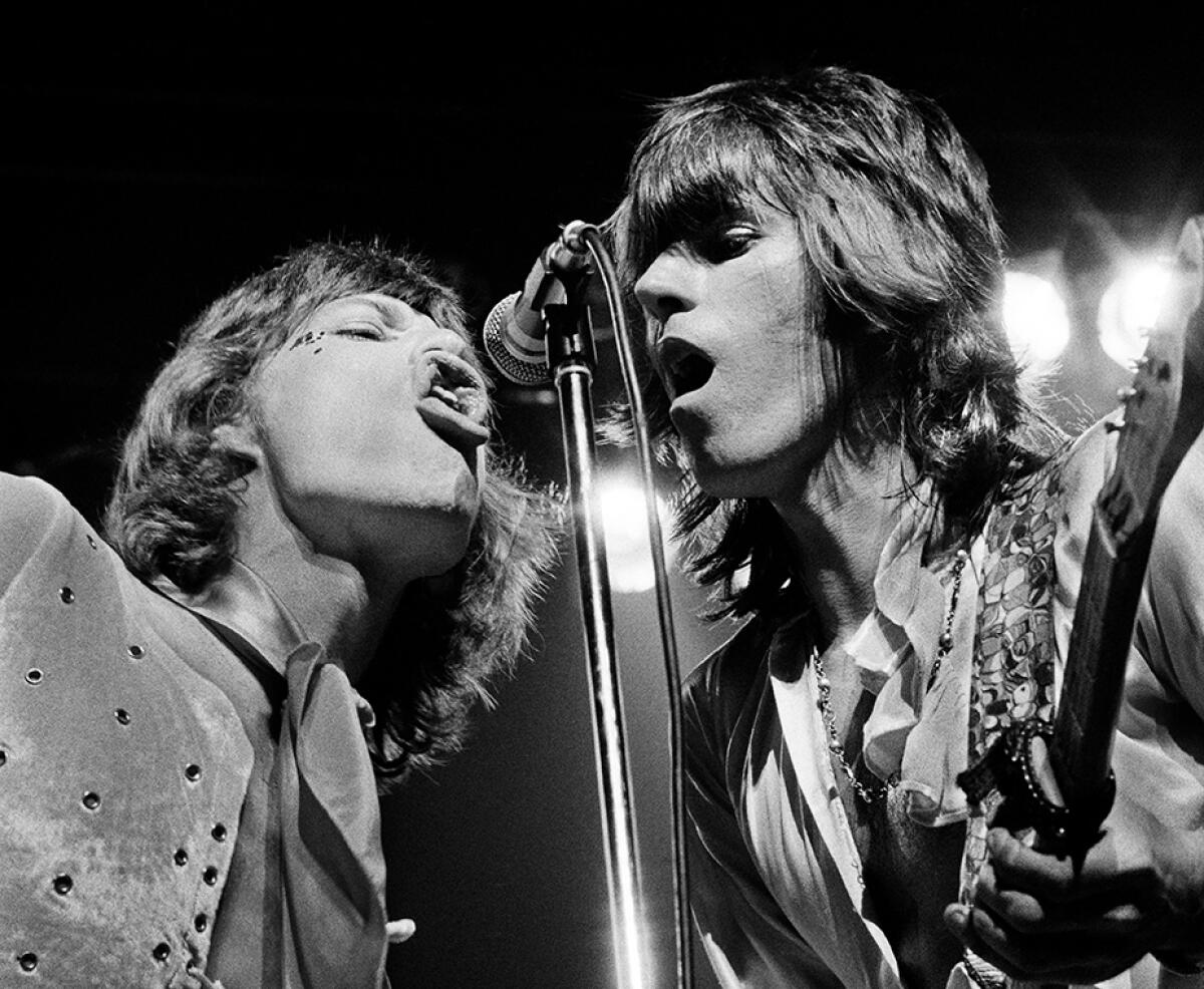 A young Mick Jagger and Keith Richards share a microphone