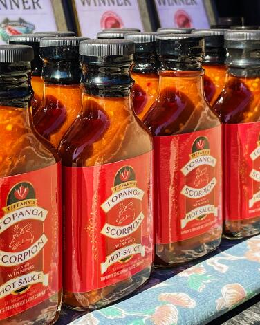 Rows of bottles of Tiffany's Topanga Scorpion Hot Sauce