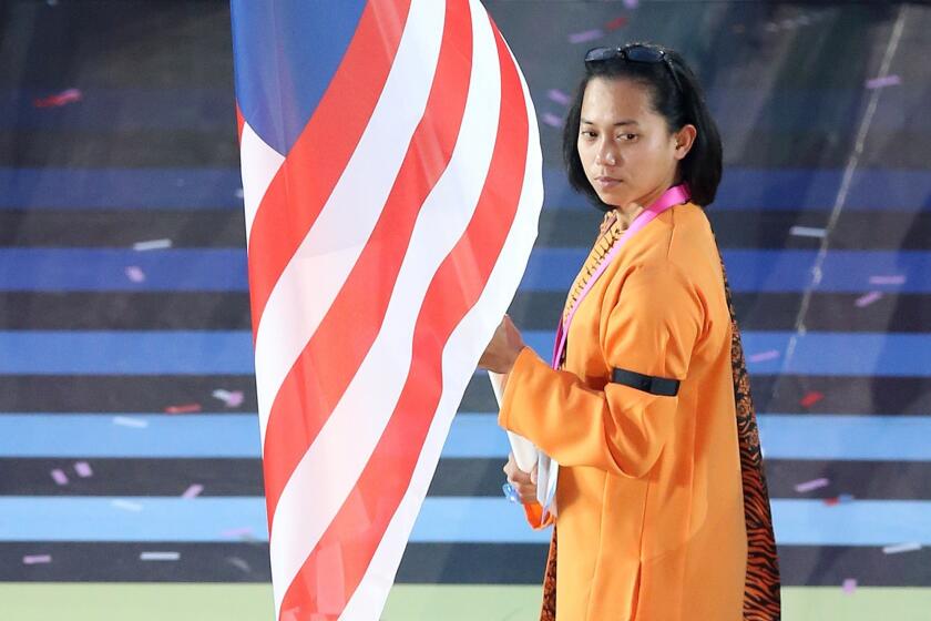 Malaysia's flag bearer Muhammad Imaadi Aba Aziz leads the team during the opening ceremony of the Commonwealth Games. The Malaysian team wore black armbands to mark the recent crash of Malaysia Airlines Flight 17.