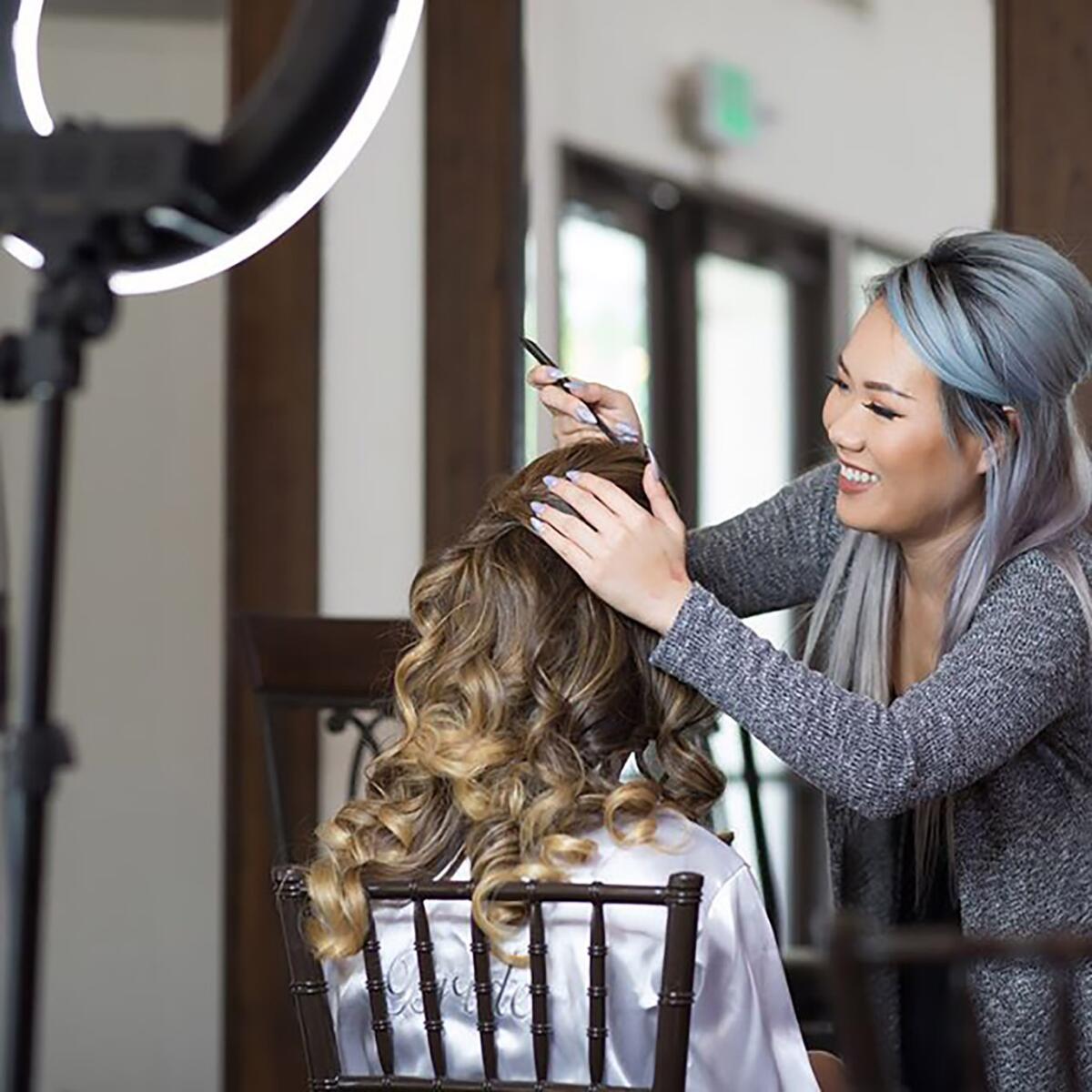 Itsada at work doing makeup for a bride.