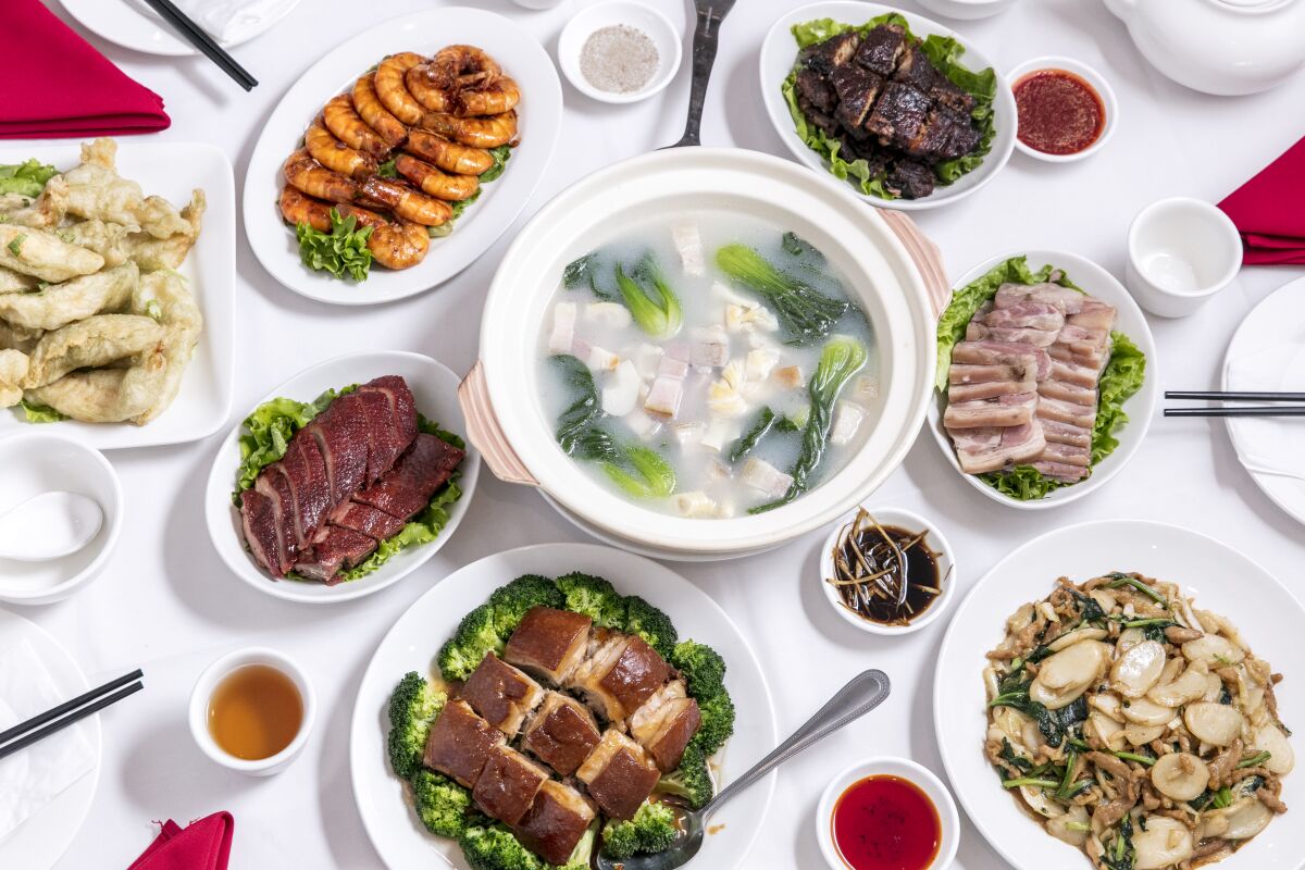 An assortment of dishes, including seaweed-flavored fried fish, Shanghai fried shrimp, smoked fish, cold pork Shanghai style, Shanghai-style rice cake with chicken, pork belly, Shanghai duck and soup with smoked pork.