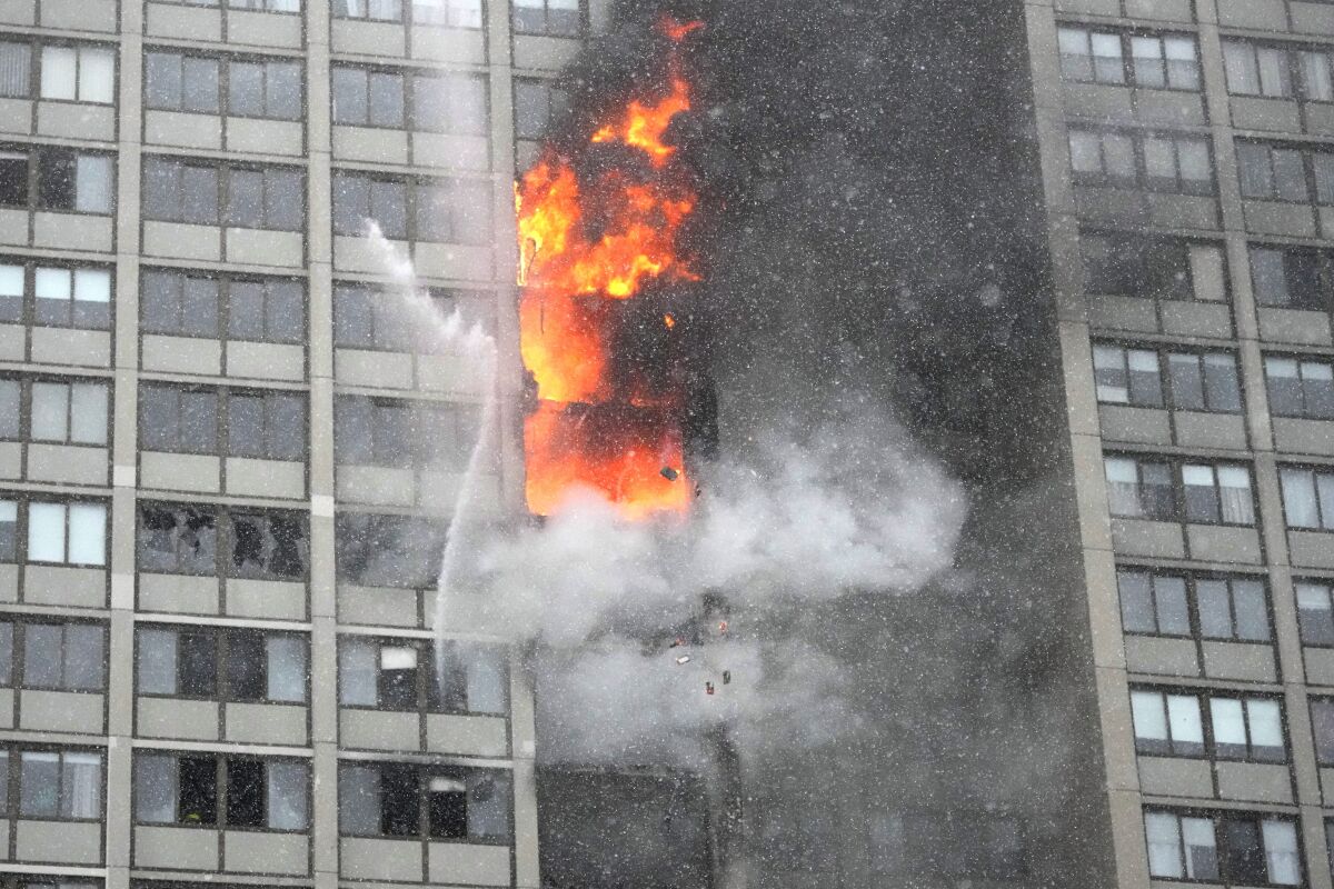 Flames leap skyward out of the Harper Square cooperative residential building in the Kenwood neighborhood of Chicago, Wednesday, Jan. 25, 2023. (AP Photo/Charles Rex Arbogast)