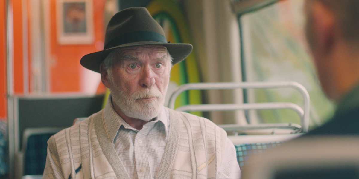 An older man riding a bus
