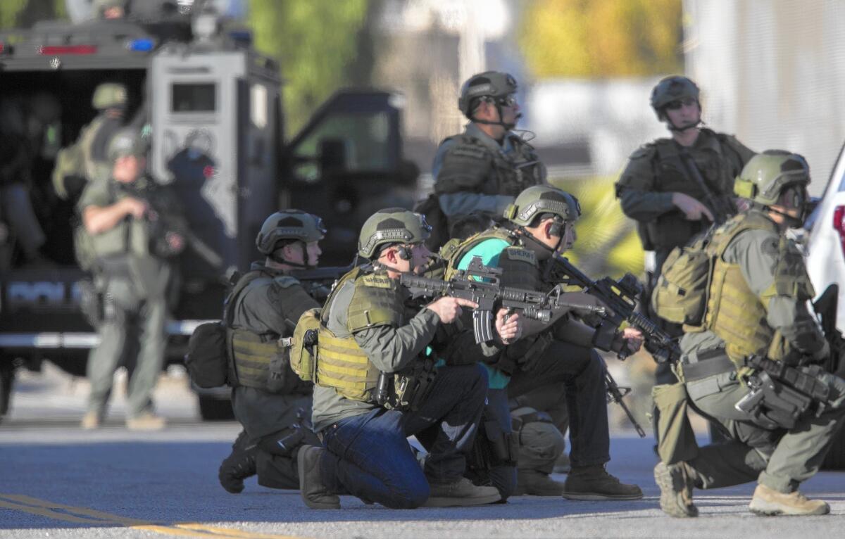 SWAT officers crouch on Richardson Street as they search for the San Bernardino shooters. (Gina Ferazzi / Los Angeles Times)