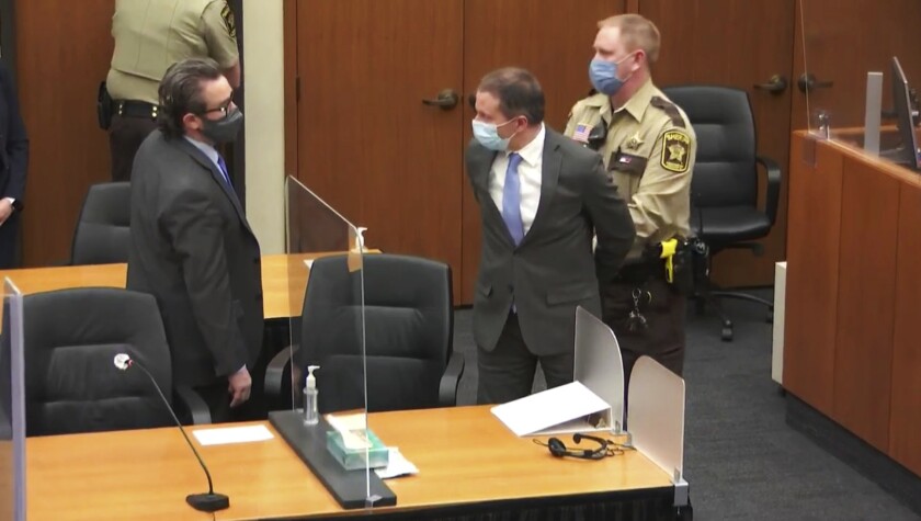 Former Minneapolis Police Officer Derek Chauvin is handcuffed in a courtroom