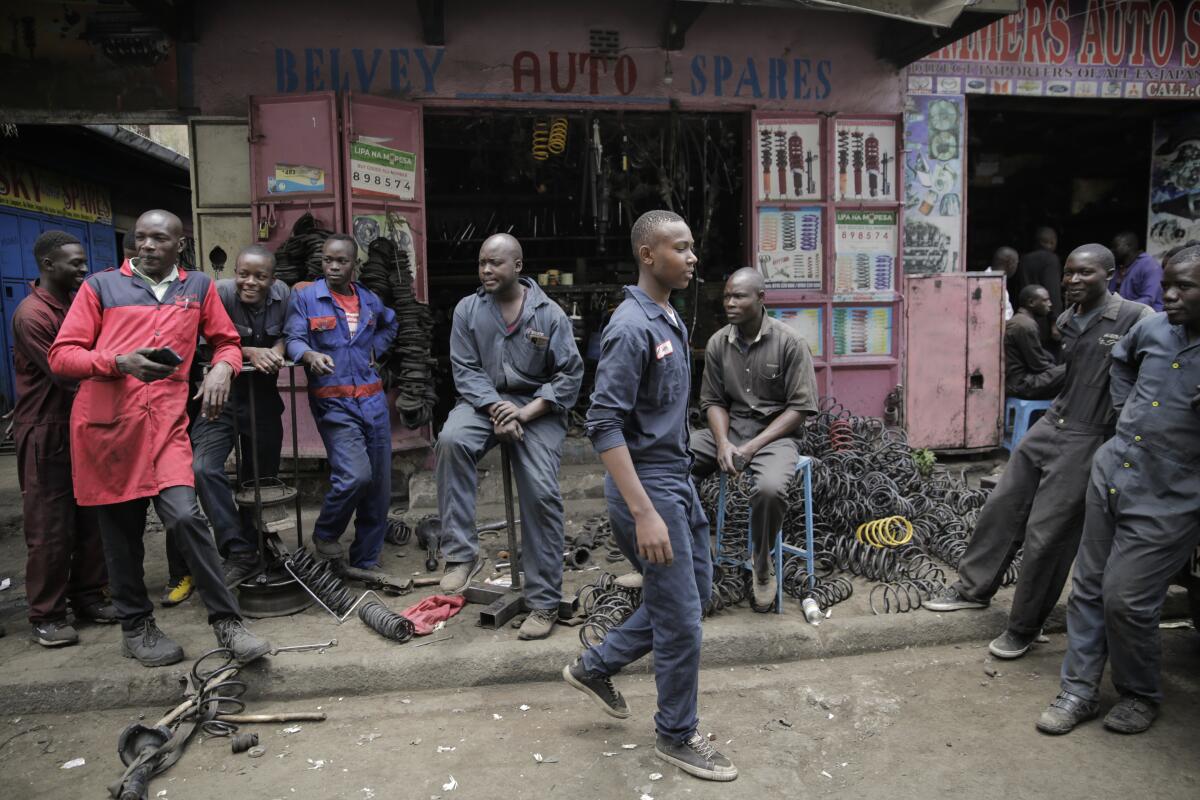 A group of workers gathers outside a secondhand auto parts shop in Nairobi.