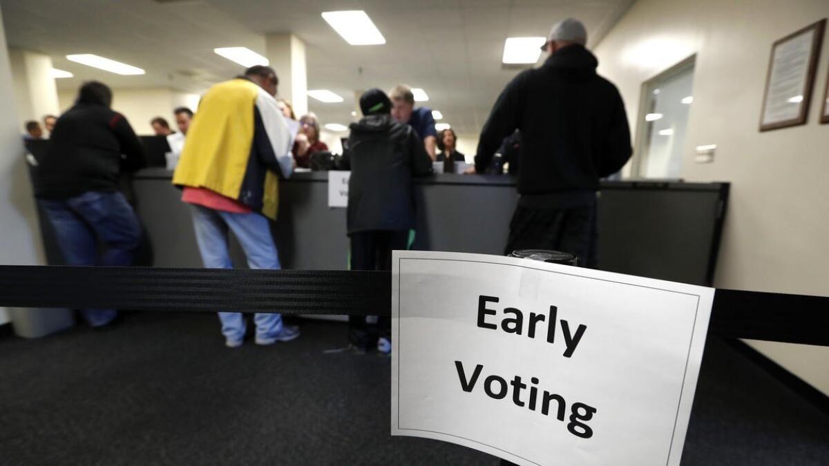 Los residentes reciben sus boletas en la Oficina de Elecciones del Condado de Polk, en el primer día de votación temprana, en Des Moines, Iowa .