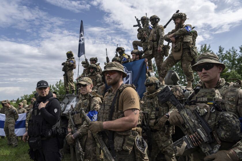 Combatientes del Cuerpo de Voluntarios Rusos se preparan para una conferencia de prensa en la región ucraniana de Sumy, cerca de la frontera con Rusia, el miércoles 24 de mayo de 2023. (AP Foto/Evgeniy Maloletka)