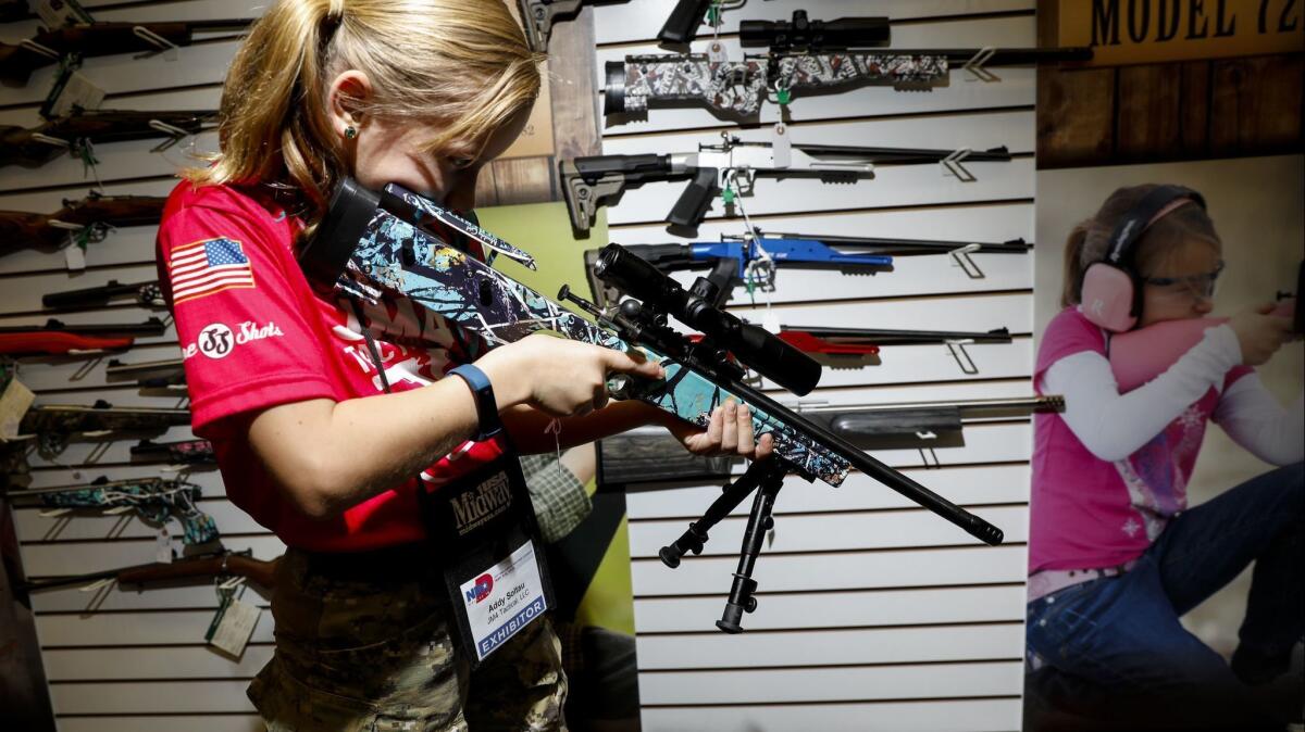 Addyson "Alpha Addy" Soltau, 9, tries out rifles in the Keystone Sporting Arms booth at the National Rifle Assn. convention in Dallas on May 6.