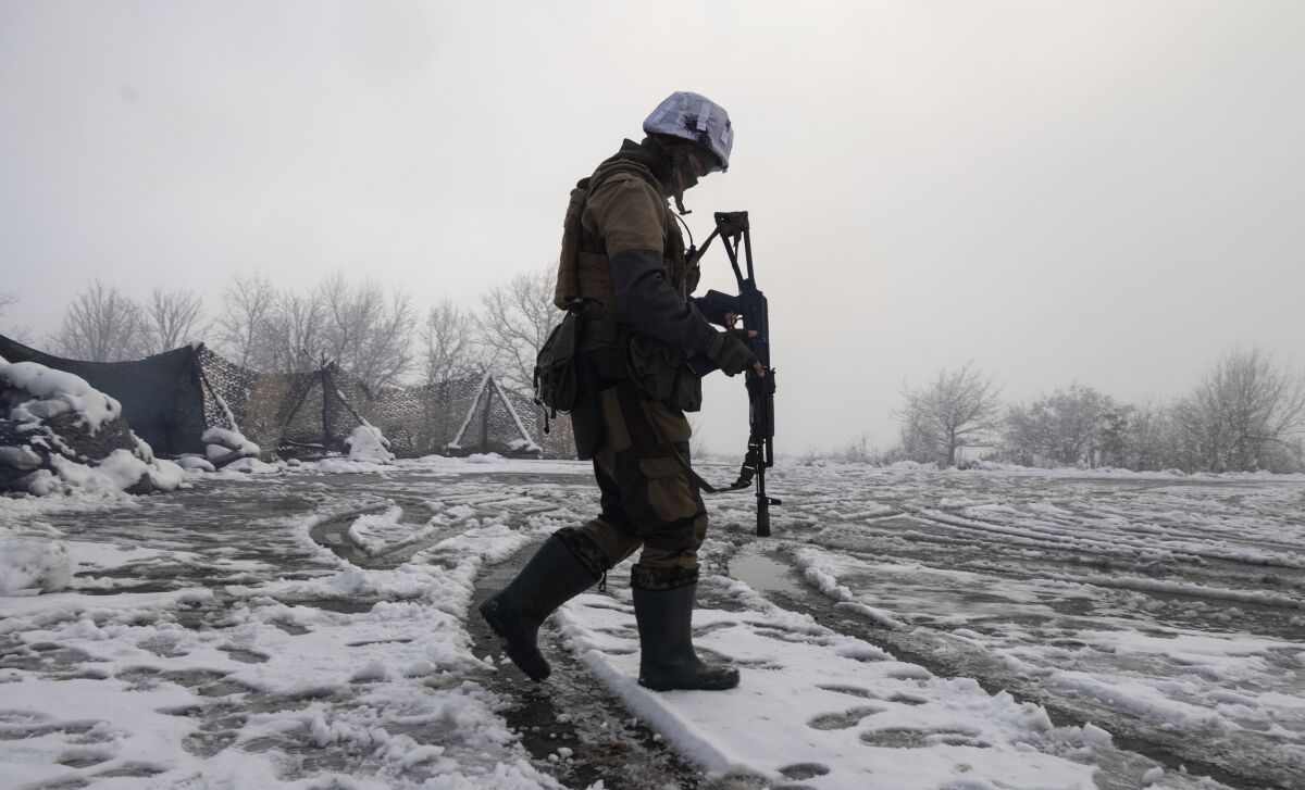 Ukrainian soldier walks across a snow-covered field