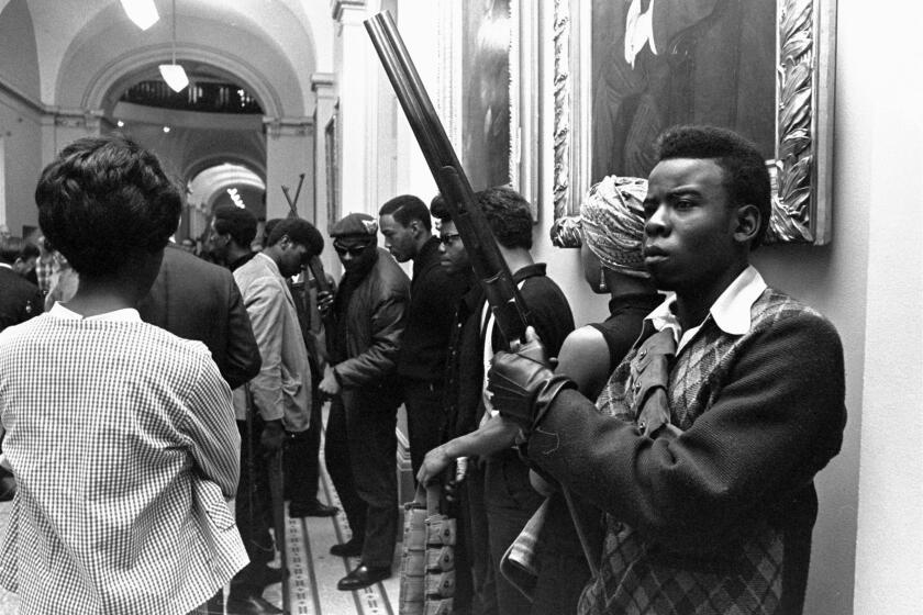 FILE - In this May 2, 1967, file photo, armed members of the Black Panthers Party stand in the corridor of the Capitol in Sacramento, Calif. Huey Newton sought to rehabilitate the Panthers' image, urging members to focus on the popular Survival Programs. He advocated for the rights of Black community to defend itself from police, but changed his view that party members should openly carry guns as a check on police brutality. (AP Photo/Walt Zeboski, File)