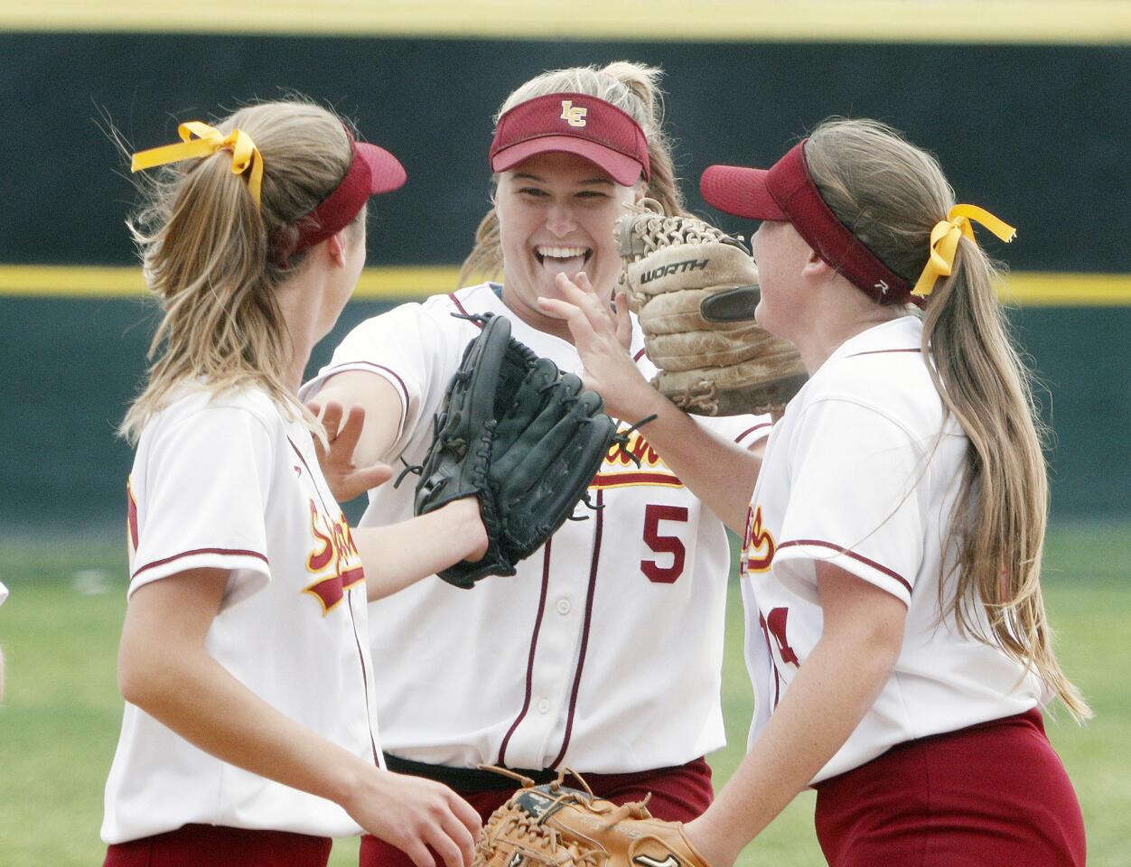 La Canada's Emily Tinkham happily slaps hands with teammates after she turned a double play against West Valley in a CIF Southern Section Division V first-round playoff softball game at La Canada High School on Thursday, May 17, 2018. La Canada won the game 4-1.