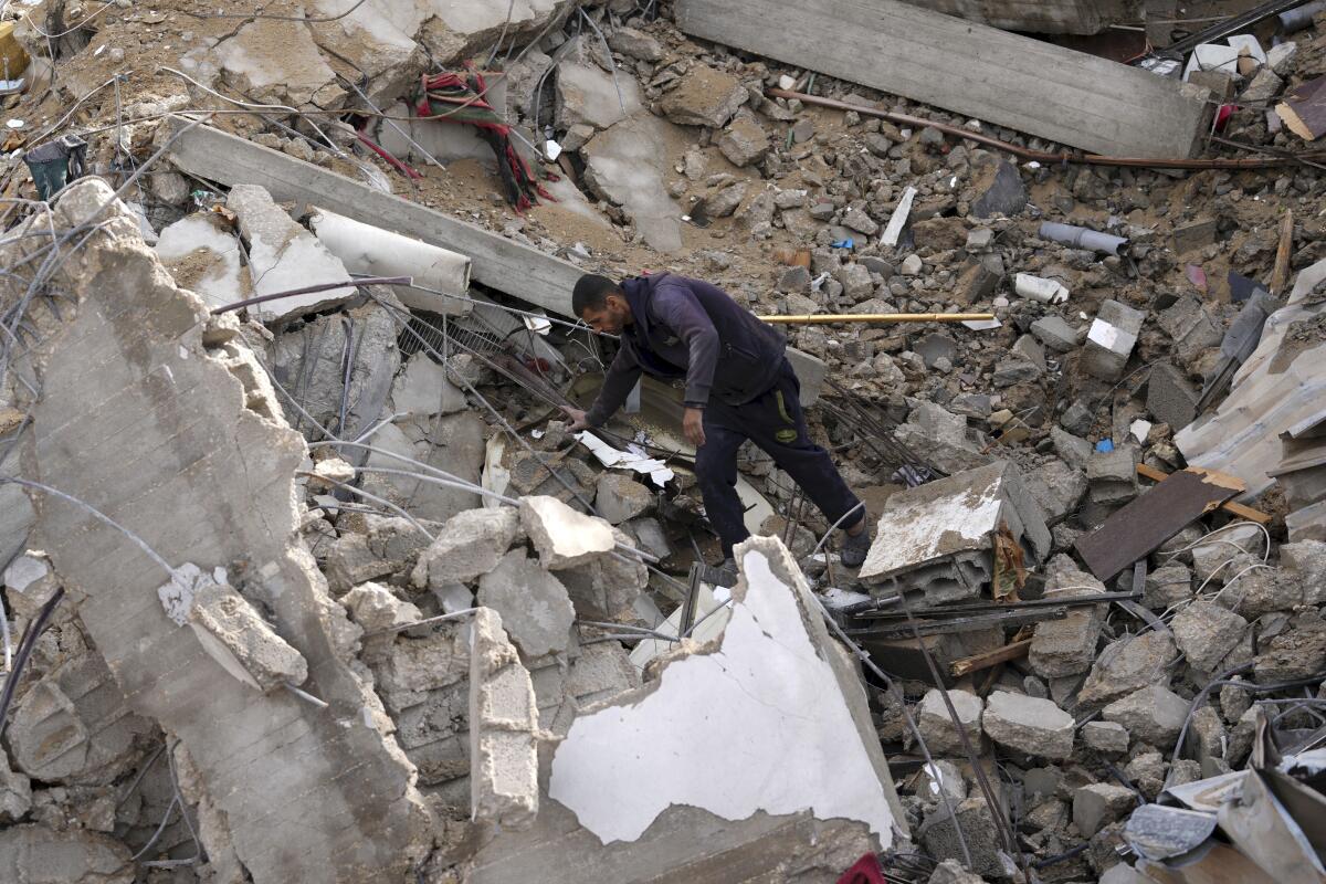 A man looks at a pile of rubble.