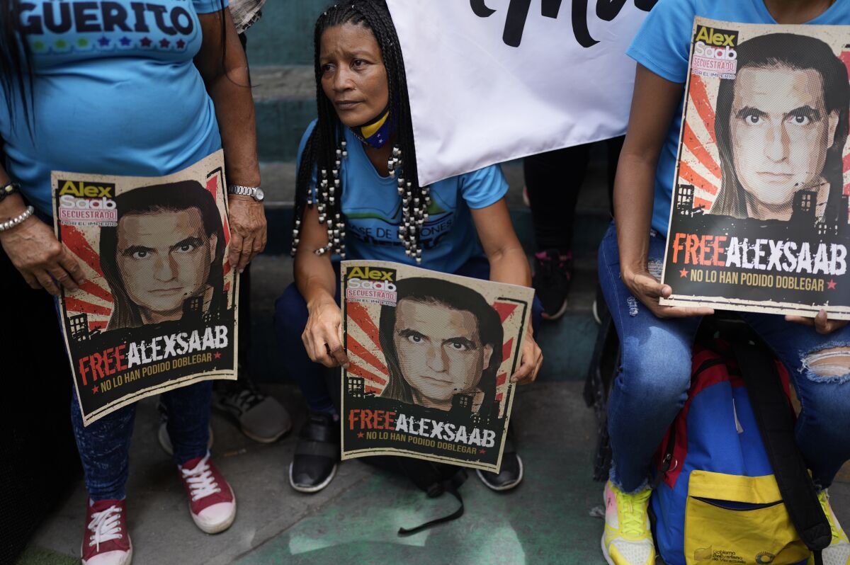 FILE - Demonstrators hold posters with the image of Alex Saab who has been extradited to the U.S., during a demonstration demanding his release, in the Petare neighborhood of Caracas, Venezuela, April 4, 2022. On May 2, 2022, a U.S. federal appeals panel thwarted Saab's attempts to be recognized as a foreign diplomat, leaving it to a lower court to decide for now whether he is immune from prosecution. (AP Photo/Ariana Cubillos, File)