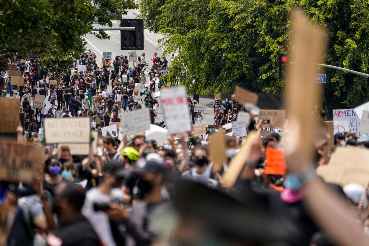 Demonstrators walk down First Street toward LAPD headquarters June 2 in Los Angeles.