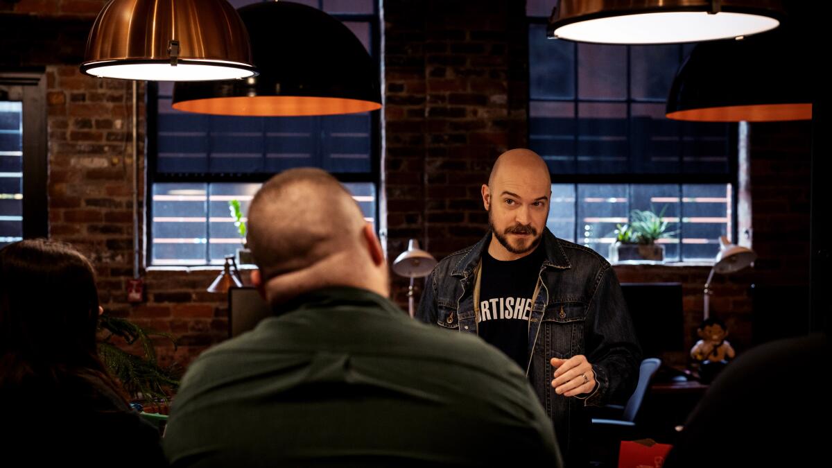 Wes Keltner talks with co-workers in the offices of video game publisher Gun Interactive in Lexington, Ky.