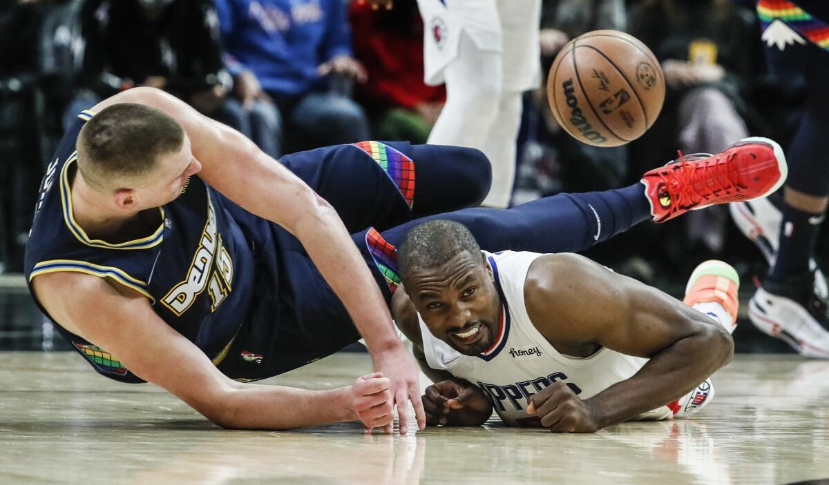 Clippers center Serge Ibaka, right, knocks the ball from Denver Nuggets center Nikola Jokic during the second half.