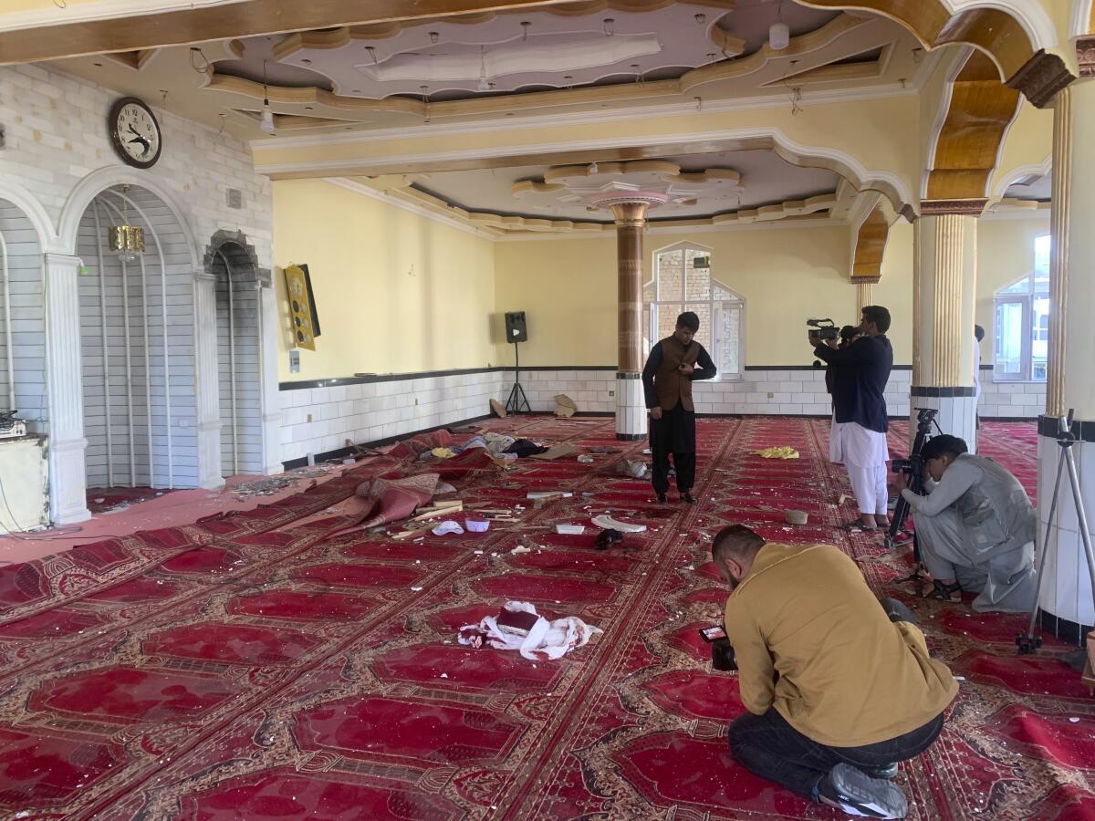 People take photos of damage inside a bombed mosque