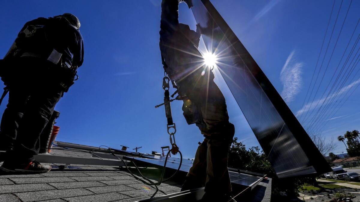 Workers install solar panels in Van Nuys. PACE loans, a controversial form of financing used by homeowners for energy-efficient improvements, are on the decline.