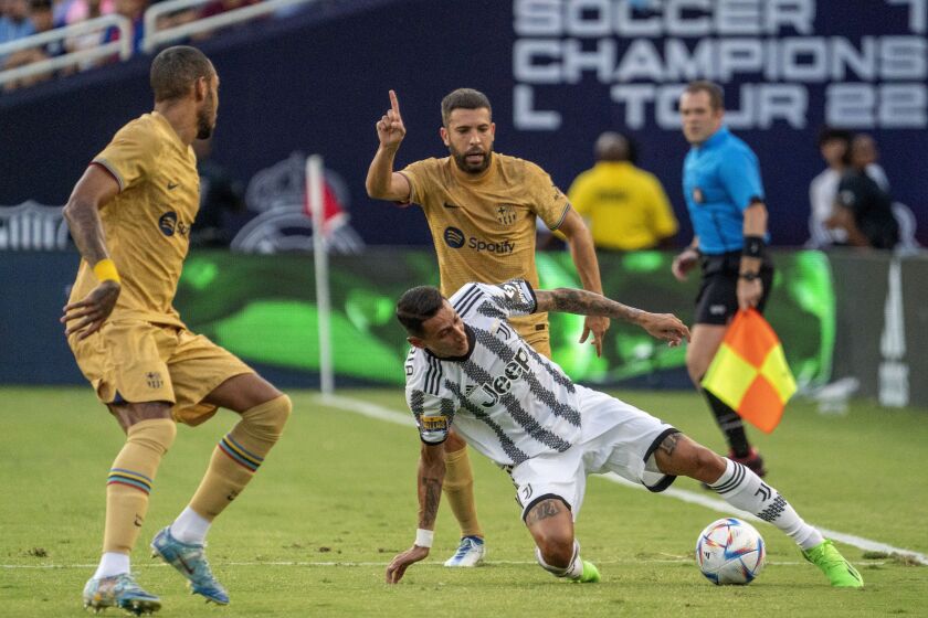 Juventus forward Angel Di Maria tries to dribble away from Barcelona defender Jordi Alba, rear, and forward Pierre Emeric Aubameyang, left, during the first half of a soccer match at the Cotton Bowl, Tuesday, July 26, 2022 in Dallas. The game ended in a 2-2 draw. (AP Photo/Jeffrey McWhorter)