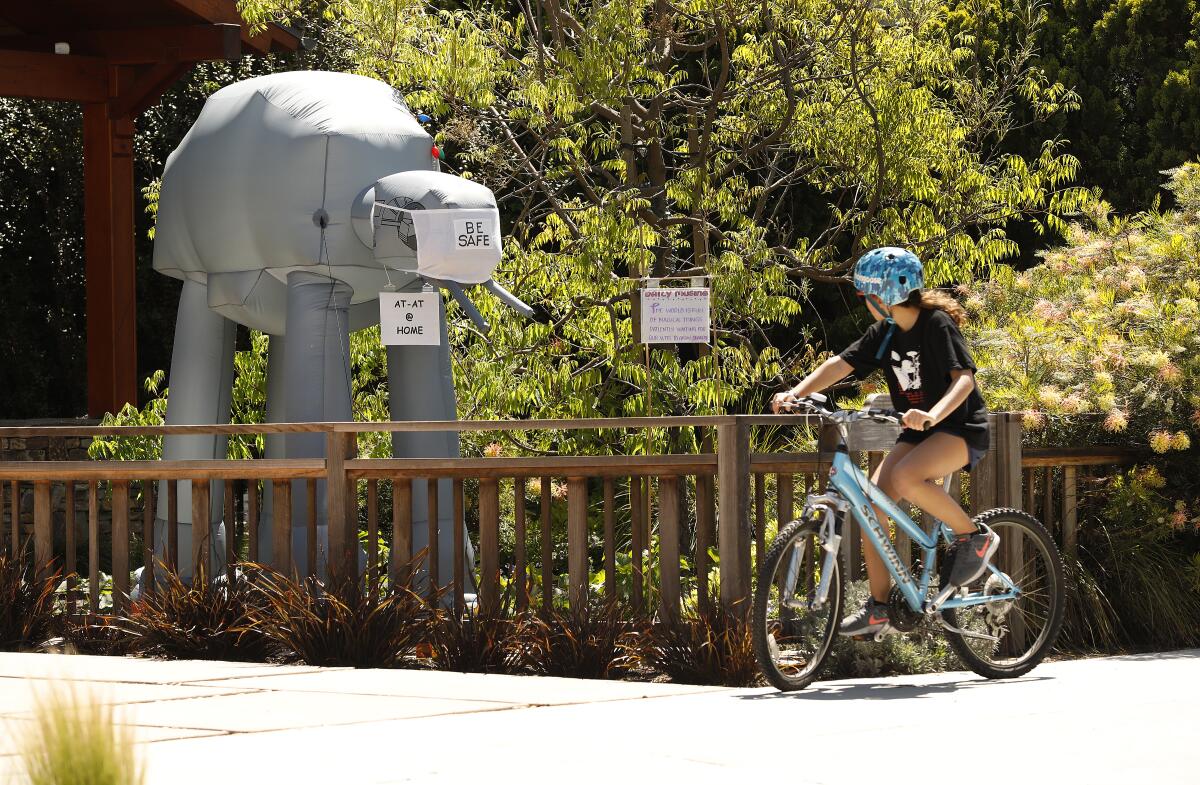 A young cyclist reads a riddle posted in her Mar Vista neighborhood.g