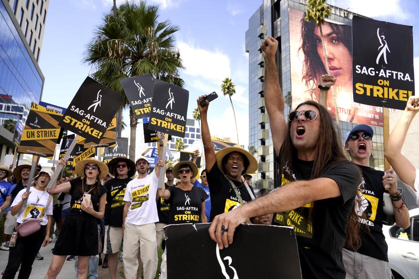 SAG-AFTRA members carry signs on the picket line outside Netflix on Wednesday, Sept. 27, 2023, in Los Angeles. 