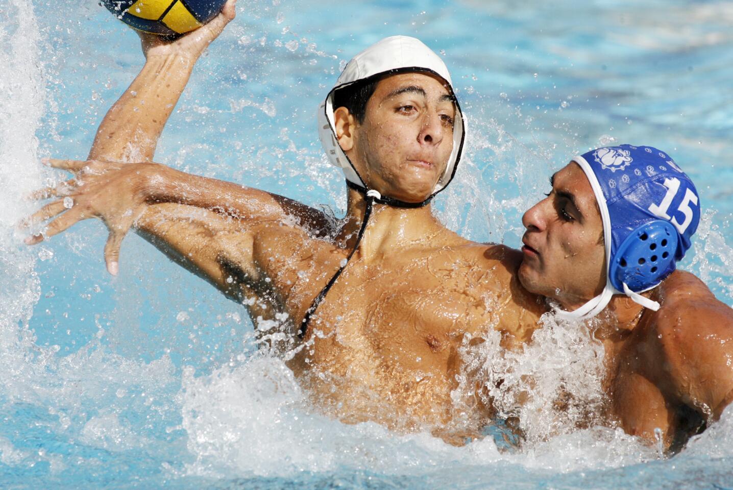 Hoover's Hakop Baghumian attempts to shoot against Burbank's Arman Toresian who's defense does enough to tangle the shot in a Pacific League boys water polo match at Burbank High School on Tuesday, October 9, 2012.