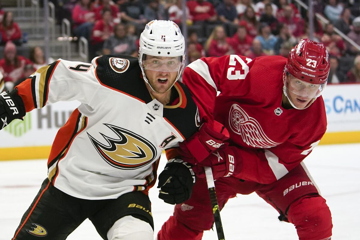 Ducks defenseman Cam Fowler, left, and Detroit Red Wings forward Lucas Raymond chase after the puck.