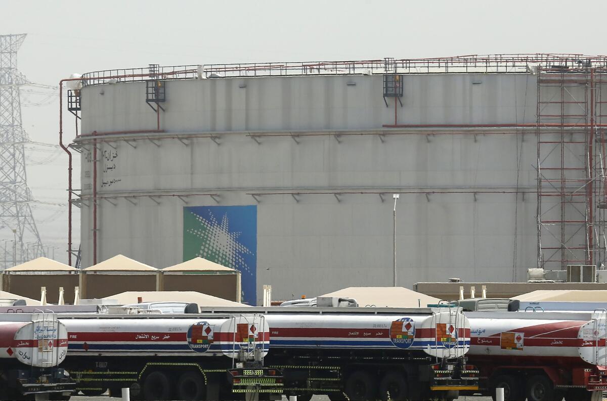 Fuel trucks line up in front of storage tanks