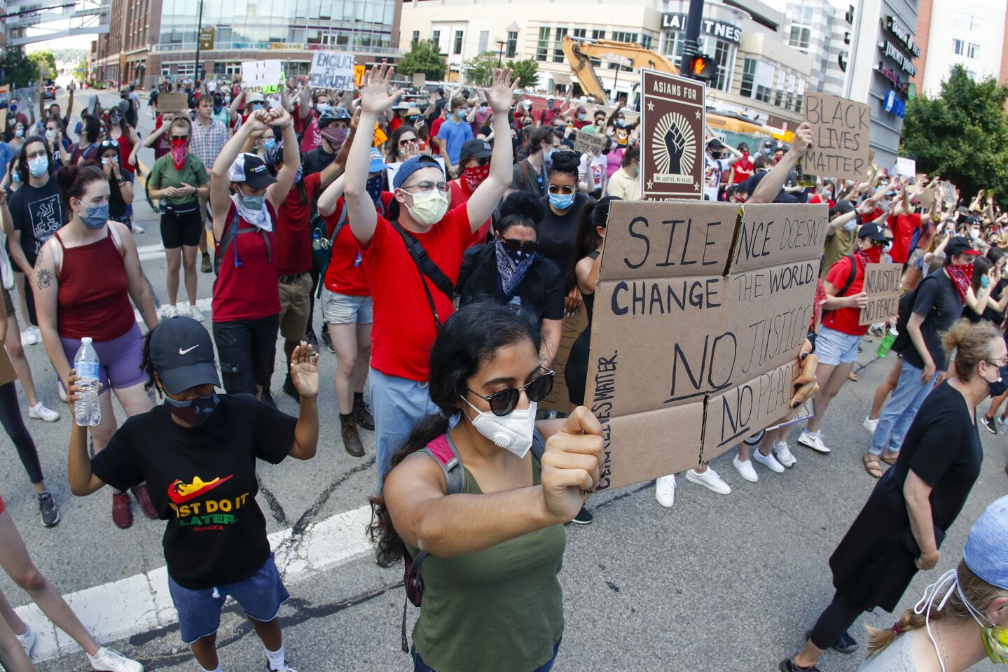 Protesters hold up signs and their hands as they chant during a protest in Pittsburgh Saturday.