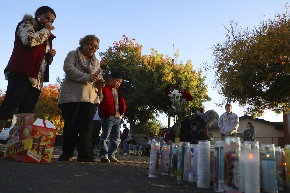 FILE - In this Nov. 24, 2019, file photo, community members gather at a memorial site in the parking lot of Searles Elementary School in Union City, Calif., after two minors were shot and killed in the parking lot the day before. Two teenage gang members have been arrested and charged for the killing of two boys in that stunned a San Francisco Bay Area community, authorities announced Friday, Feb. 14, 2020. Jason Cornejo, 18, of Castro Valley, and a 17-year-old boy from Hayward were charged Thursday with the murders of Sean Withington, 14, and Kevin Hernandez, 11, said Union City Police Chief Jared Rinetti. (Aric Crabb/Bay Area News Group via AP, File)