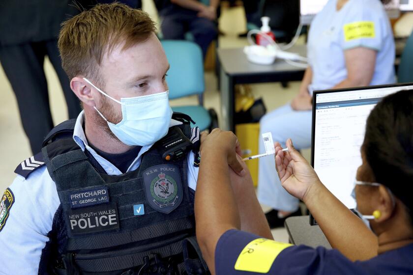 New South Wales Police officer Lachlan Pritchard receives the Pfizer vaccine at the Royal Prince Alfred Hospital Vaccination Hub in Sydney, Australia, Monday, Feb. 22, 2021. Australia has started its COVID-19 vaccination program days after its neighbor New Zealand with both governments deciding their pandemic experiences did not require regulation short cuts. (Toby Zerna/Pool Photo via AP)