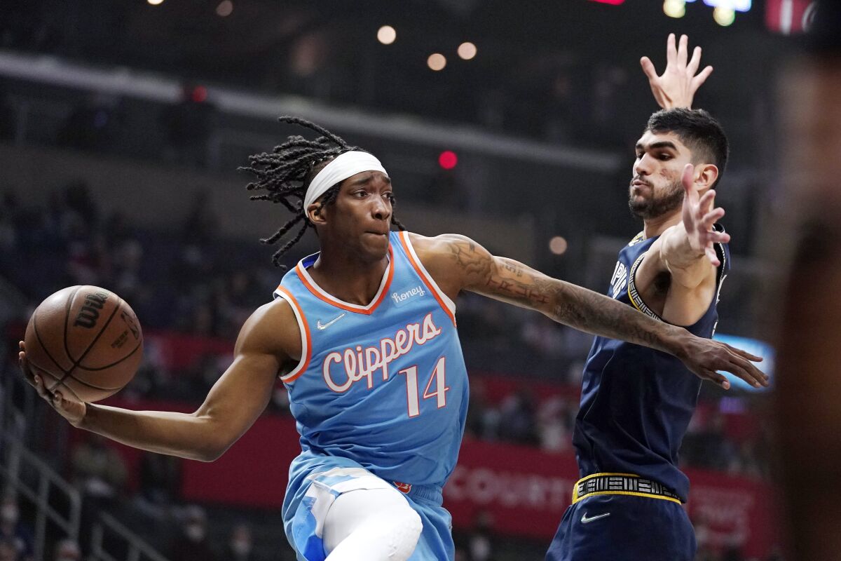Clippers guard Terance Mann, left, passes the ball in front of Memphis Grizzlies forward Santi Aldama.