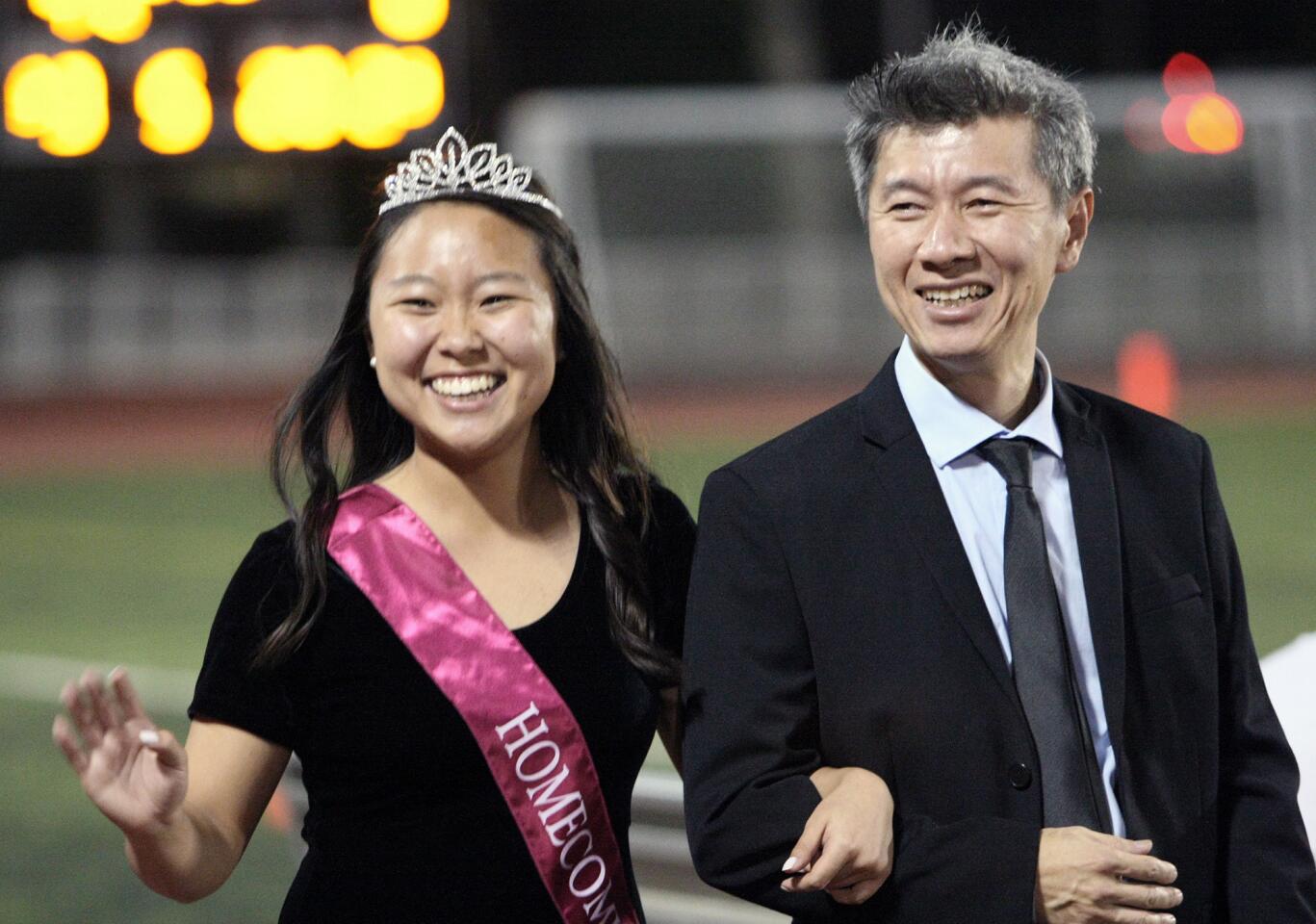 Homecoming court member Sofia Kim is escorted by her father Gabriel during halftime at the La Cañada High School football game on Friday, Oct. 16, 2015.