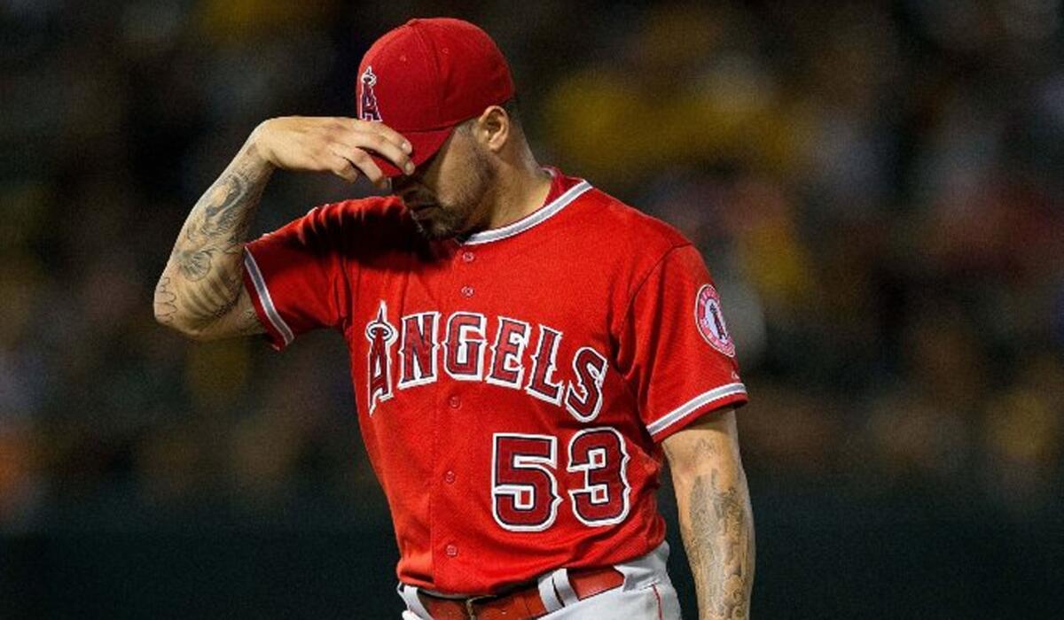 Angels starting pitcher Hector Santiago returns to the dugout after being relieved in the third inning against the Athletics on Monday.