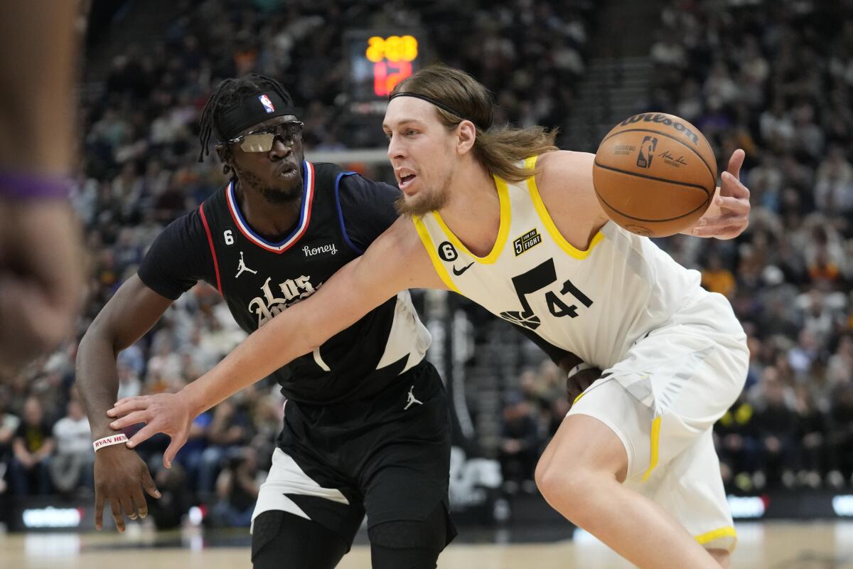 Utah Jazz forward Kelly Olynyk drives to the basket as Clippers guard Reggie Jackson defends.