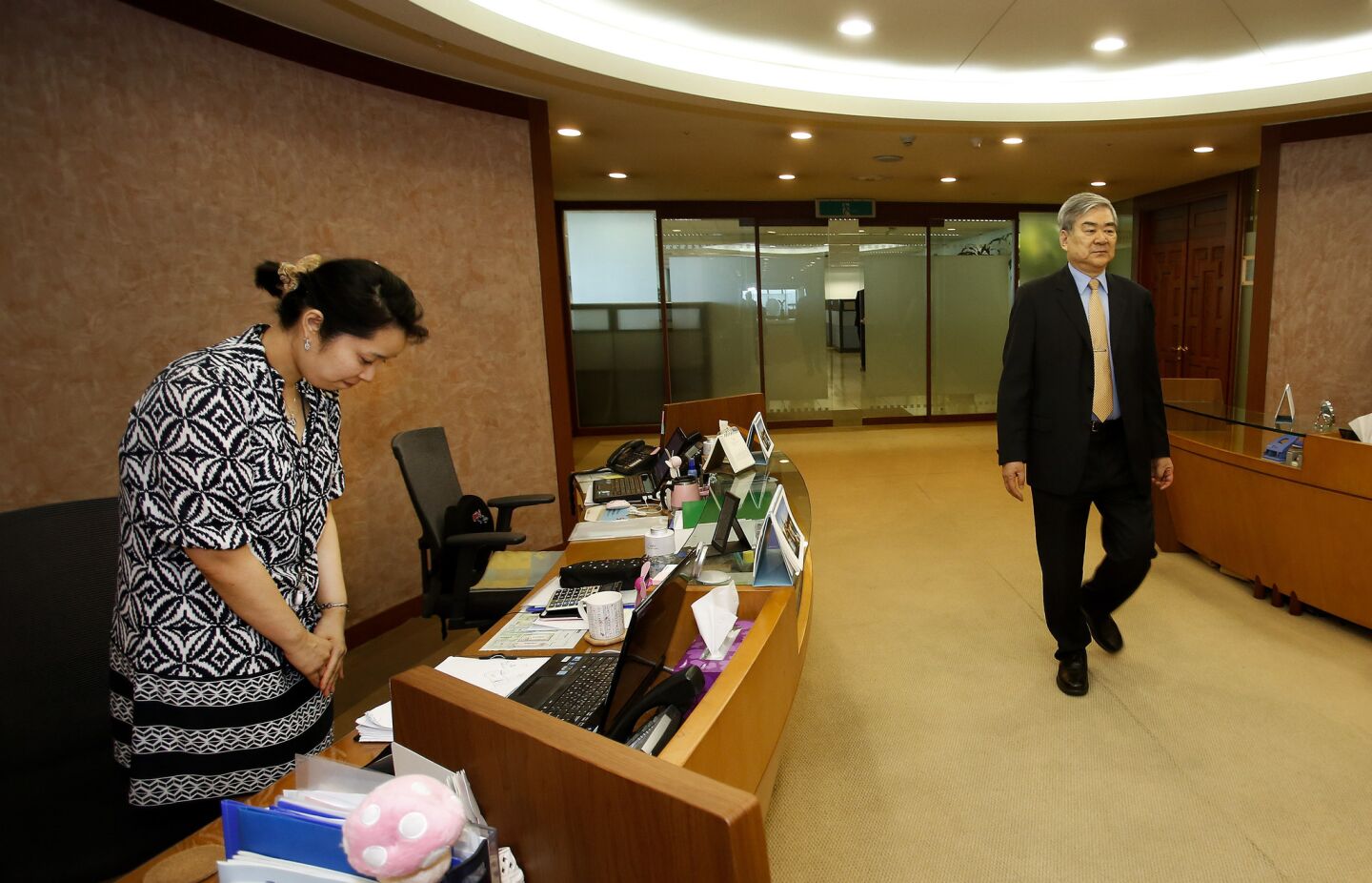 A secretary bows her head as Yang Ho Cho, Chairman of Korean Air, makes his way into his office at Korean Air's headquarters in Seoul, Korea.