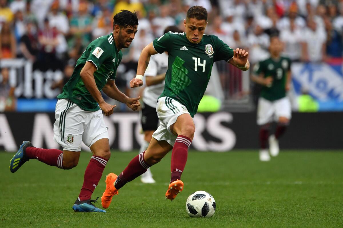 Mexico's Javier "Chicharito" Hernández, right, drives the ball past forward Carlos Vela during the 2018 World Cup.