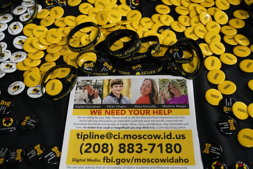 FILE - A flyer seeking information about the killings of four University of Idaho students who were found dead is displayed on a table along with buttons and bracelets on Nov. 30, 2022, during a vigil in memory of the victims in Moscow, Idaho. Police are asking for help finding the occupant of a car that was seen near where the students were stabbed to death last month, saying that person could have "critical information" about the case. (AP Photo/Ted S. Warren, File)