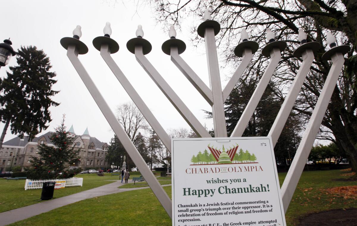 A menorah bears a "Happy Chanukah!" sign in a public park