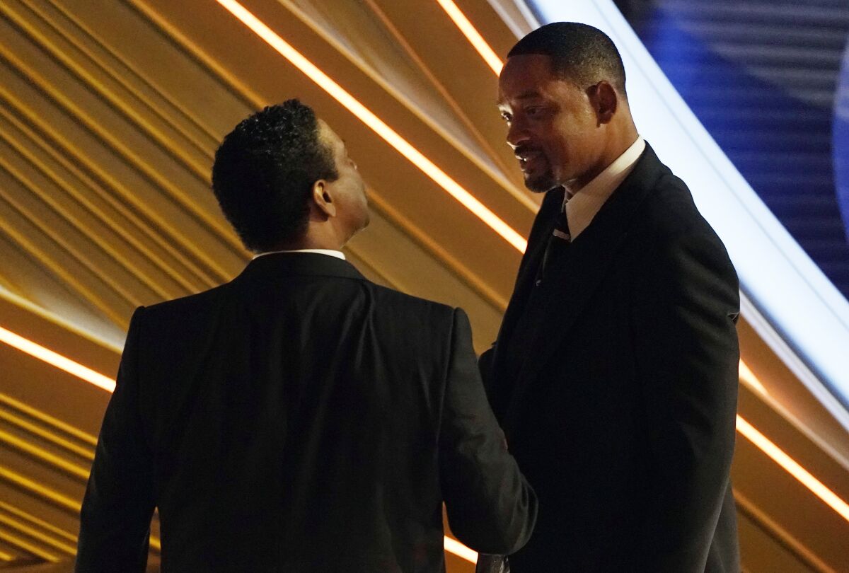 Denzel Washington, left, talks with Will Smith during the 94th Academy Awards