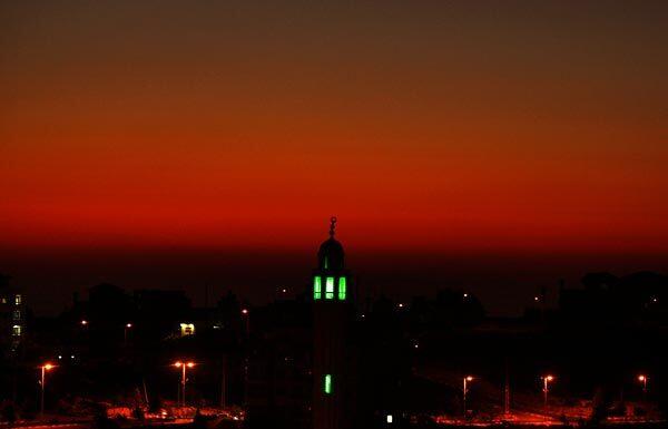 The sunset colors the sky behind a mosque in the West Bank city of Ramallah on the third day of the Muslim holy fasting month of Ramadan. Muslims across the world are celebrating the holy month during which observant Muslims fast from dawn till dusk, abstaining from food, drink and other physical pleasures and focusing on prayer and meditation.