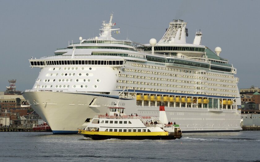 A ferry passes in front of the Explorer of the Seas cruise ship in 2007. A court ruling says the family of a man who died after being injured on the ship can pursue a negligence suit against Royal Caribbean Cruises.